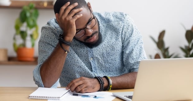 Man frustrated looking at laptop 
