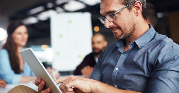 Man looking at emails on tablet