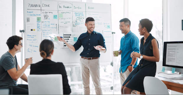 Marketers standing by a white board
