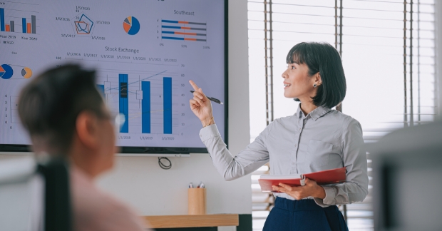 Woman reading off marketing metrics in meeting