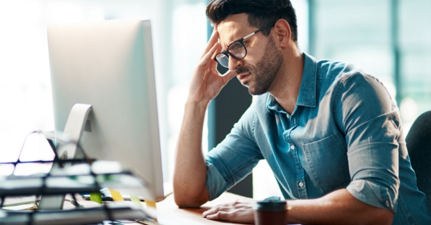 Frustrated tech marketer looking at computer