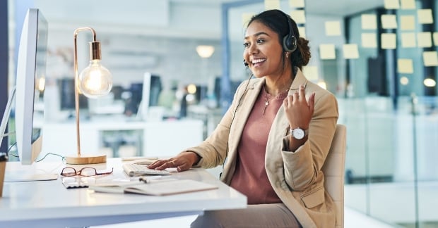 Woman sitting at desk speaking on headset