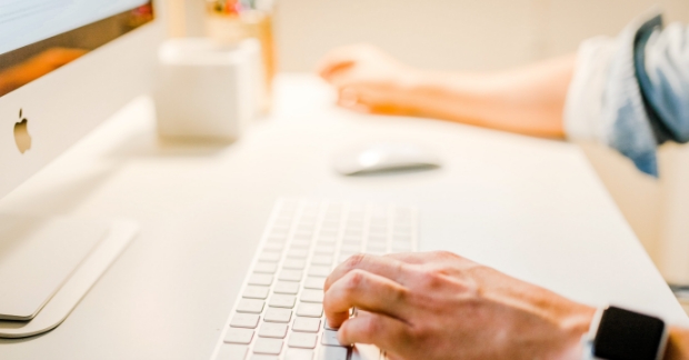 Close-up of man on computer typing 