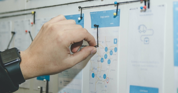 Person working on workflows on a corkboard