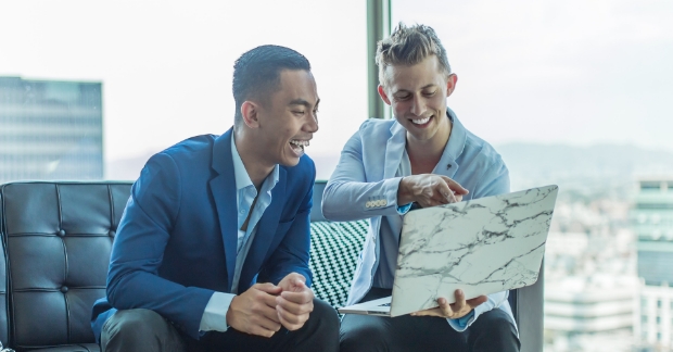 Man and woman smiling at laptop