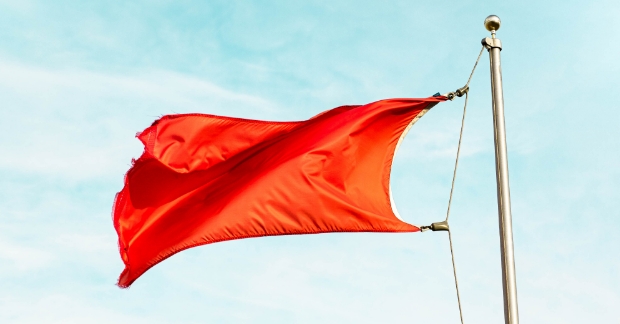 red flag waving with blue sky in background